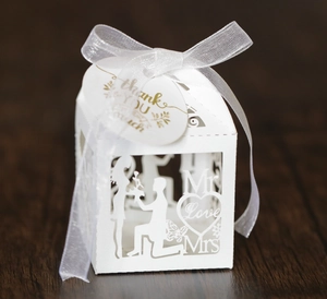 Detailed laser-cut white wedding favor box with romantic proposal patterns and silk ribbon