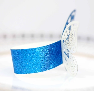 Detalle macro de servilletero azul brillante con adorno de mariposa cortada con láser