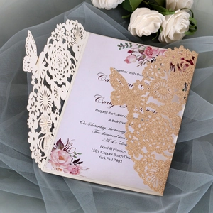 Detail of laser-cut butterfly wedding invitation with gold glitter and floral inner card