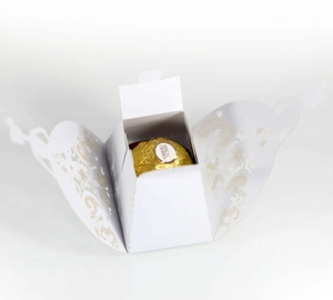 Close-up of laser-cut white favor box with elegant lace pattern for chocolate