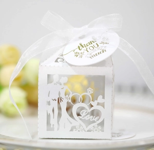 Macro detail of white laser-cut wedding favor box with heart and Love cutout patterns
