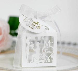 Laser-cut white wedding favor box with Mr & Mrs heart pattern and white ribbon bow