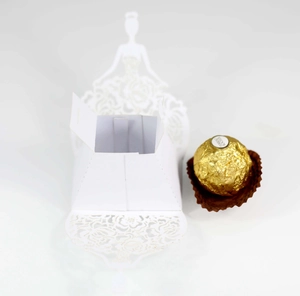 Macro detail of white laser-cut butterfly candy box with elegant hollow flower patterns