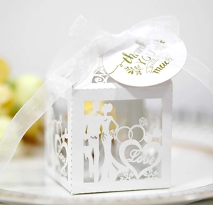 Detail of white laser-cut wedding favor box with Love text, ribbon and thank you tag