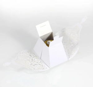 Detailed laser-cut flower patterns on white wedding favor box for chocolate