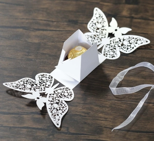 Macro view of white laser-cut butterfly candy box with delicate hollow floral patterns