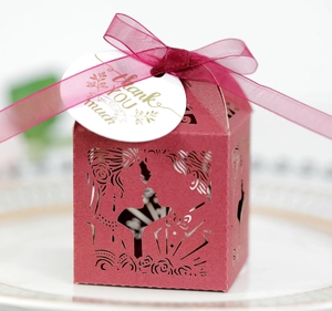 Macro detail of red hollow favor box with kissing couple cutout and Thank You tag