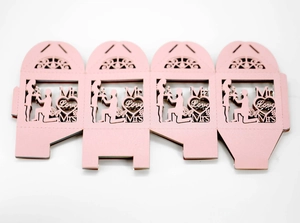Laser-cut pink wedding favor box showing the flat unfolded structure with love motifs