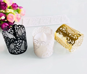 Macro shot of laser-cut hollow leaf patterns on gold, black and white candle paper sleeves