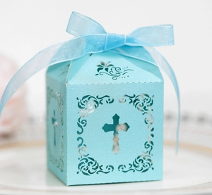 Détail de la boîte cadeau ajourée bleu clair avec motif croix et ruban élégant