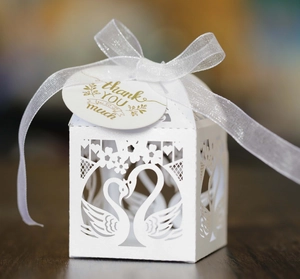 White laser-cut swan heart wedding favor box with white ribbon and thank you tag