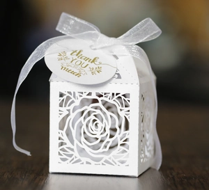 Close-up of white laser-cut rose gift box with a sheer bow and gold Thank You tag