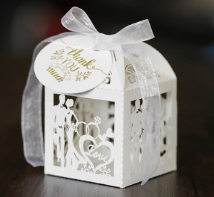 Detail of white laser-cut wedding candy box with bride groom motif and Thank You tag