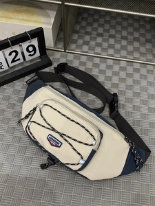 Sporty cream and navy nylon crossbody bag with adjustable strap and bungee cord detail