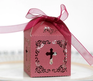 Détail d'une boîte cadeau ajourée avec croix en papier perlé et ruban organza