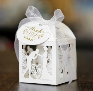 Detailed laser-cut wedding favor box with heart patterns and silk ribbon bow