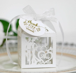 Detail of white laser-cut wedding favor box with Love motif and thank you tag
