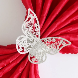 Elegante servilletero de mariposa con purpurina plateada sobre tela de raso roja