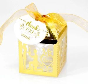 Detail of laser-cut gold wedding favor box with Love heart and Mr & Mrs design