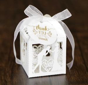 Detail of white laser-cut wedding gift box with heart hollow and thank you tag