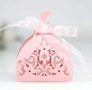 Pink laser-cut dress-shaped favor box with delicate flower pattern and ribbon