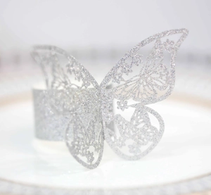Detalle del servilletero mariposa plateado con purpurina y diseño calado cortado por láser