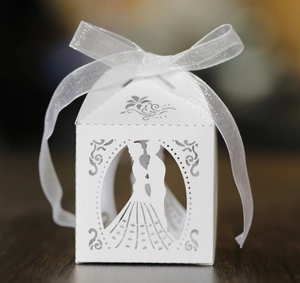 Close-up of laser cut wedding favor box with bride and groom silhouette and ribbon