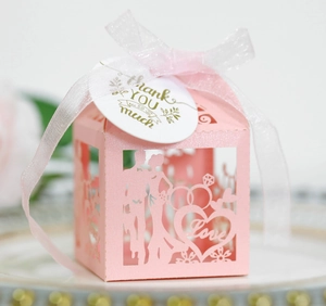 Detail of pink laser-cut wedding favor box with glitter finish and Thank You tag