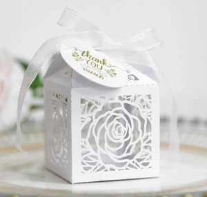 Close-up of laser-cut rose gift box with white chiffon ribbon and thank you tag