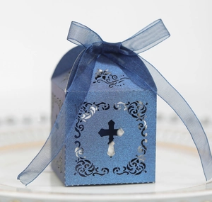 Vue macro d'une boîte cadeau bleue découpée au laser avec croix évidée et ruban élégant