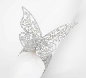Detalle de servilletero de mariposa plateada con purpurina y diseño calado por láser