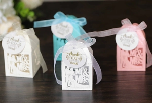 Detail of laser cut wedding favor boxes with Mr & Mrs design and thank you tags