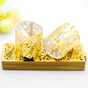 Golden hollowed-out paper candle wrap with laser-cut vine patterns for festive decor