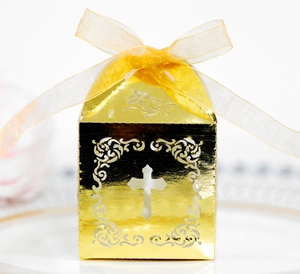 Détail de découpe laser en forme de croix sur boîte cadeau dorée pour mariage