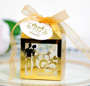 Detail of golden laser-cut wedding favor box with Love heart motif and thank you tag