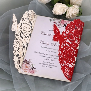 Detail of laser-cut butterfly wedding invitation with glitter finish on mesh background