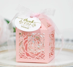 Detail of pink laser-cut rose hollow favor box with silk ribbon and thank you tag