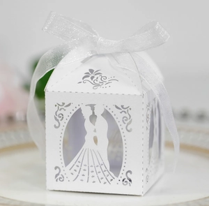Detail of white laser-cut wedding candy box with bride and groom silhouette and ribbon