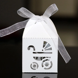 Close-up of laser-cut baby carriage hollow design on white paper gift favor box