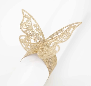 Detalle de servilleteros de mariposa dorada con purpurina cortada con láser para bodas