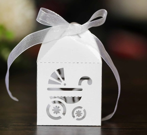 Detail of white laser-cut baby carriage candy box with matching white ribbon bow