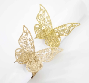 Detalle de servilletero de mariposa con purpurina dorada y diseño calado cortado a láser