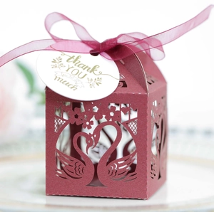 Detail of red laser-cut swan favor box with pearl paper texture and thank you tag