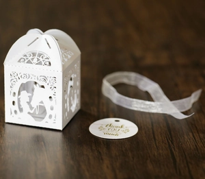 Detail der weißen Laserschnitt-Geschenkbox mit Karussell-Silhouette und Danksagungsanhänger