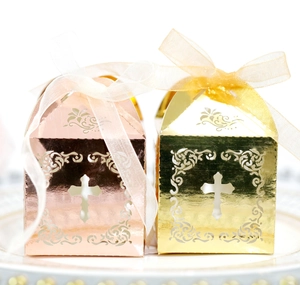 Détail de boîtes cadeaux croix découpées au laser en or rose et doré avec ruban