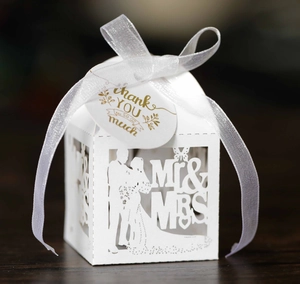 Detail of white laser-cut wedding favor box with Mr & Mrs silhouette and Thank You tag