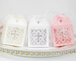 Détail de boîtes à dragées mariage découpées au laser avec croix et rubans en organza soyeux