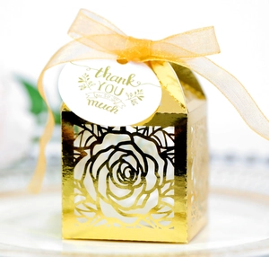 Close-up of rose gold cutout wedding candy box with thank you tag and ribbon detail