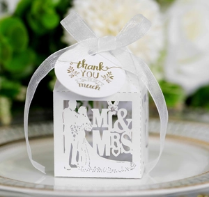 Close-up of laser-cut wedding favors box with Mr & Mrs silhouette and white ribbon
