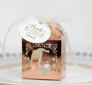 Detail of rose gold hollow favor box with horse girl silhouette and white ribbon